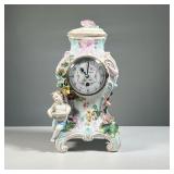 CHARLES DUPONT PORCELAIN CLOCK | Showing a winged putti / cherub among blossoming, colorful flowers.