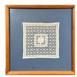 FRAMED DOILY | Doily on blue matt framed behind glass. - l. 15.5 x w. 16 in (overall)