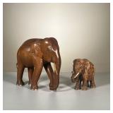 (2PC) CARVED WOODEN ELEPHANTS | Hand-carved wooden elephant figure with a smaller plaster statue. 