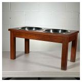 DOG FEEDING STAND | 2 stainless steel dog bowls in wood stand with cutouts. - l. 23.5 x w. 11.5 x h.