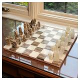 STONE CHESS SET | Stone chess board with matching carved stone chess pieces. - l. 14 x w. 14 x h. 1 
