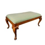 CARVED UPHOLSTERED OTTOMAN | Carved wood ottoman with a green upholstered cushion, cabriole legs wit