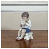 BING & GRONDAHL BOY DRINKING TEA CERAMIC FIGURINE | Ceramic figurine of boy drinking tea sitting on 