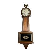 Banjo Clock | Banjo clock with a natural wood finish, eagle finial, reverse painted églomisé tablet,