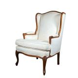 OFF WHITE WING BACK ARMCHAIR | Wing back armchair with carved arms and legs and off white cushion. -
