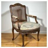 FRENCH CARVED ARM CHAIR | Cane seat and backrest carved decorations. - l. 26 x w. 24 x h. 36 in 