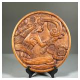CARVED PLAQUE | Hand-carved, round, wooden plaque depicting a seated Mayan figure precisely carved i