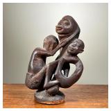 HAND CARVED AFRICAN STATUE | Shows motherly figure holding two children. - l. 5 x w. 5 x h. 9 in 