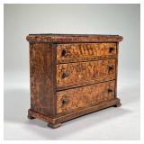 GRAIN-PAINTED MINIATURE CHEST OF DRAWERS | Having three graduated drawers. - l. 7 x w. 3 x h. 6 in