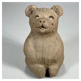 CLAY BEAR FIGURINE | Seated clay bear figurine with big smile, signed on bottom. - l. 5.25 x w. 5.5 