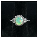 OPAL & STERLING RING | Designed as a sterling silver ring with large mounted opal bordered by melee 