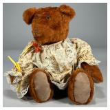 Early Plush Bear | Densely stuffed teddy bear in a floral patterned dress, with no apparent tag or l