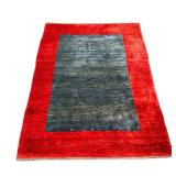 Persian Gabbeh Carpet | Handmade Persian wool rug, having a blue ground within a thick red border. -