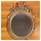 FORMED GILT MIRROR | Oval mirror with formed gilt frame having flower relief. - h. 19 x w. 14 in