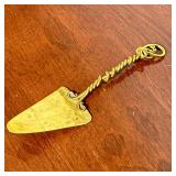 SIGNED BRASS CAKE SERVER | Double turned and scrolled handle, signed “Joe Spoon” or “Jae Spoon” and 