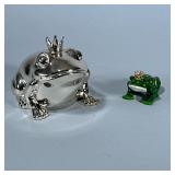 (2pc) DECORATIVE FROGS | Chromed prince frog coin bank and ceramic prince frog. - h. 4 x w. 3.5 x l.
