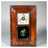 E.N. WELCH SHELF CLOCK | Having a burl veneered case with eglomise painted panel of a bird, the face