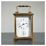 FRENCH CARRIAGE CLOCK | Brass case with beveled glass panels, including a top oval window, the face 