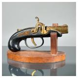 VINTAGE DERRINGER LIGHTER | Plugged derringer pistol-form lighter with brass barrel, on a wood stand