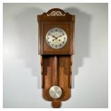 CARVED OAK WALL CLOCK | With a stepped carved case. - h. 34.5 x w. 12.5 x d. 6 in