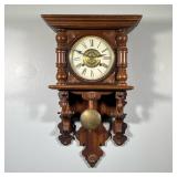 CARVED WOOD WALL CLOCK | The face with Roman numeral markers and central pressed brass medallion; wi