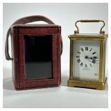 EMANUEL SOUTHAMPTON CARRIAGE CLOCK | A brass carriage clock with five beveled glass panels in a red 