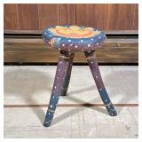 Folk Art Tripod Stool | Carved and polychromed wood, the seat with a sun face, having polka dots on 