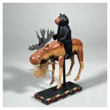BEAR RIDING MOOSE | Wood carved bear riding a moose on wood stand - h. 10.25 x w. 2.5 x l. 6 in