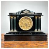 Enameled Shelf Clock | Heavy black enameled metal mantel clock with pressed brass scrollwork face wi
