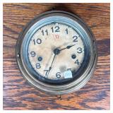 Wall Clock | Round wall clock with Arabic numeral markers, the face marked with a red "D" inside a f