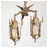 CUPID BRASS FIGURAL TWO-LITE HANGING FIXTURE | Gilt toned metal brass hanging light fixture designed
