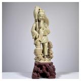 CARVED STONE FIGURE | Carved jade or stone Chinese figure of a fisherman on a contrasting stone carv