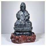 Carved Black Stone Buddha | Heavy, on a carved conforming wood stand. - h. 7.75 x w. 4.5 x d. 4 in
