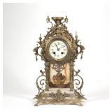 "GUSTAV BECKER ONYX & BRASS SHELF CLOCK | Having ornate gilt brass scroll work and carved onyx h. 17
