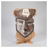 "LARGE AFRICAN MASK | Carved wood African mask painted half white with straw hair and animal hide on