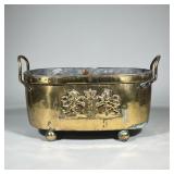 LARGE BRASS CACHETPOT LION INSIGNIA | Oblong cachetpot with balled feet and two handles. Raised lion