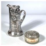 (2pc) SILVER OVERLAY FLORAL PITCHER AND LIDDED POWDER BOX | A sterling silver overlay glass pitcher 