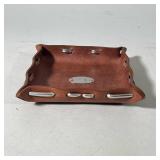 Leather Tray | Leather tray with metal weaved through rim. Fisherman’s fly medallion in middle. Mark