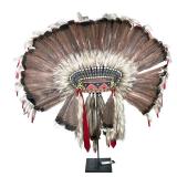 NATIVE AMERICAN HEADDRESS | Having intricate beadwork headband with large crown of feathers, on a me