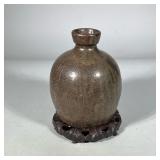 JAPANESE CERAMIC VASE | Japanese ceramic vase with calligraphy-style decoration, on a carved wood ba