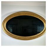 Giltwood Oval Wall Mirror | Vintage giltwood oval mirror, featuring a gold painted frame adorned wit