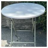 Round Folding Cocktail Table (1/2) | Round folding cocktail table with a white tabletop and gray ste