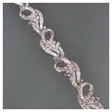 DIAMOND & 14K WHITE GOLD RIBBON FORM BRACELET | Designed as 6 white gold & diamond hinged stations, 