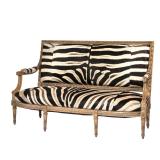 ZEBRA UPHOLSTERED LOUIS XVI SETTEE | Having finely stitched zebra backrest, seat, and armrests, rais