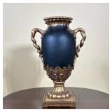 NEOCLASSICAL STYLE BLACK AND GILT COMPOSITE URN | Matte black ovoid body with applied gold-tone comp