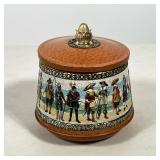 #65 LIDDED TIN JAR WITH HISTORICAL MILITARY FIGURES | Small lidded tin jar with a continuous lithogr
