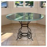ROUND GLAZED GREEN STONE DINING TABLE ON WROUGHT IRON BASE | Round dining table featuring a thick gl