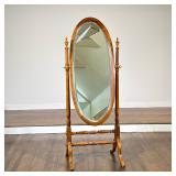 MAHOGANY OVAL CHEVAL MIRROR | An oval tilting mirror is mounted within a mahogany wood frame. The st