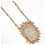 LOT 101 | CHINESE CELADON JADE OVAL OPENWORK PENDANT | Carved flower heads within recessed Greek key