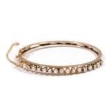 LOT 483 | PEARL & DIAMOND 14K HARD BRACELET | Having 9 round diamonds alternating with 9 pearls, set